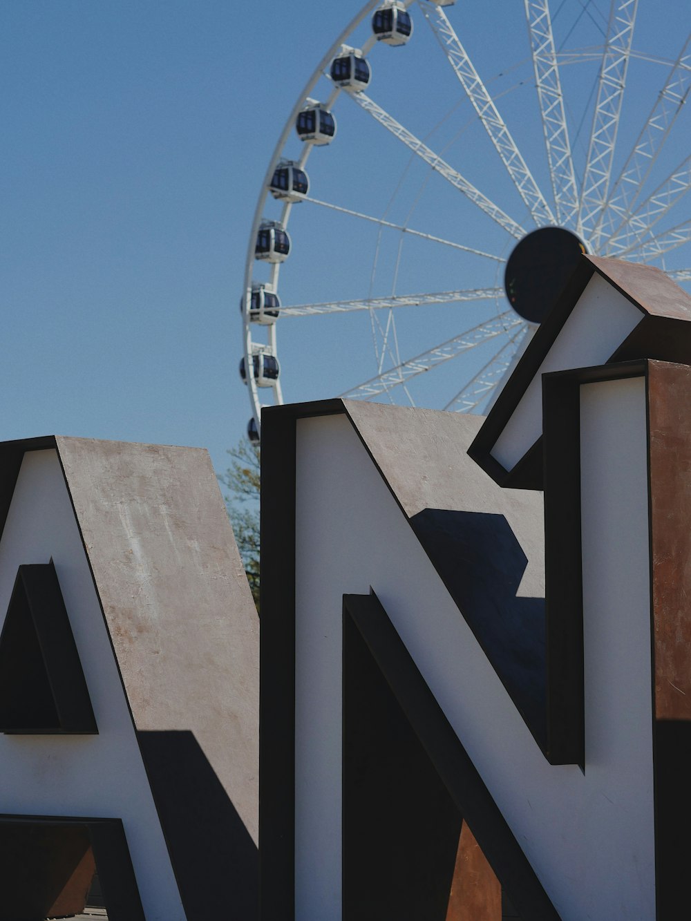 a large sign with a ferris wheel in the background