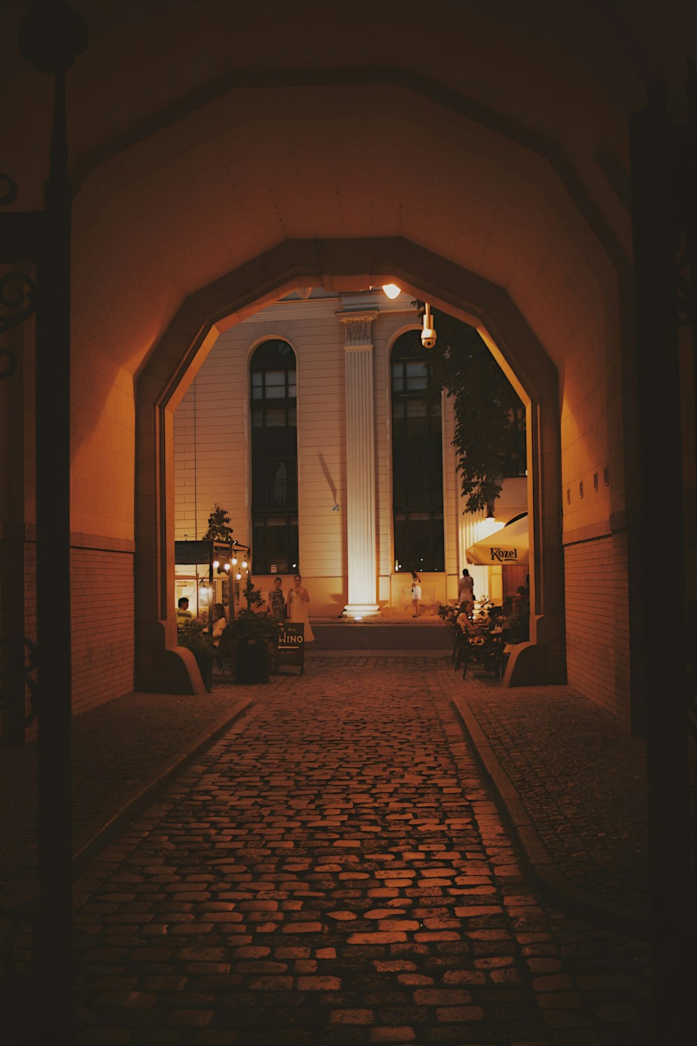 a cobblestone street with a light at the end of it