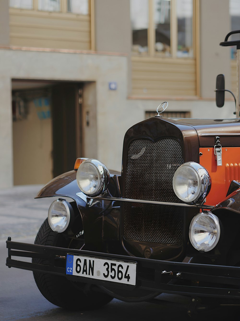 an old fashioned car parked in front of a building