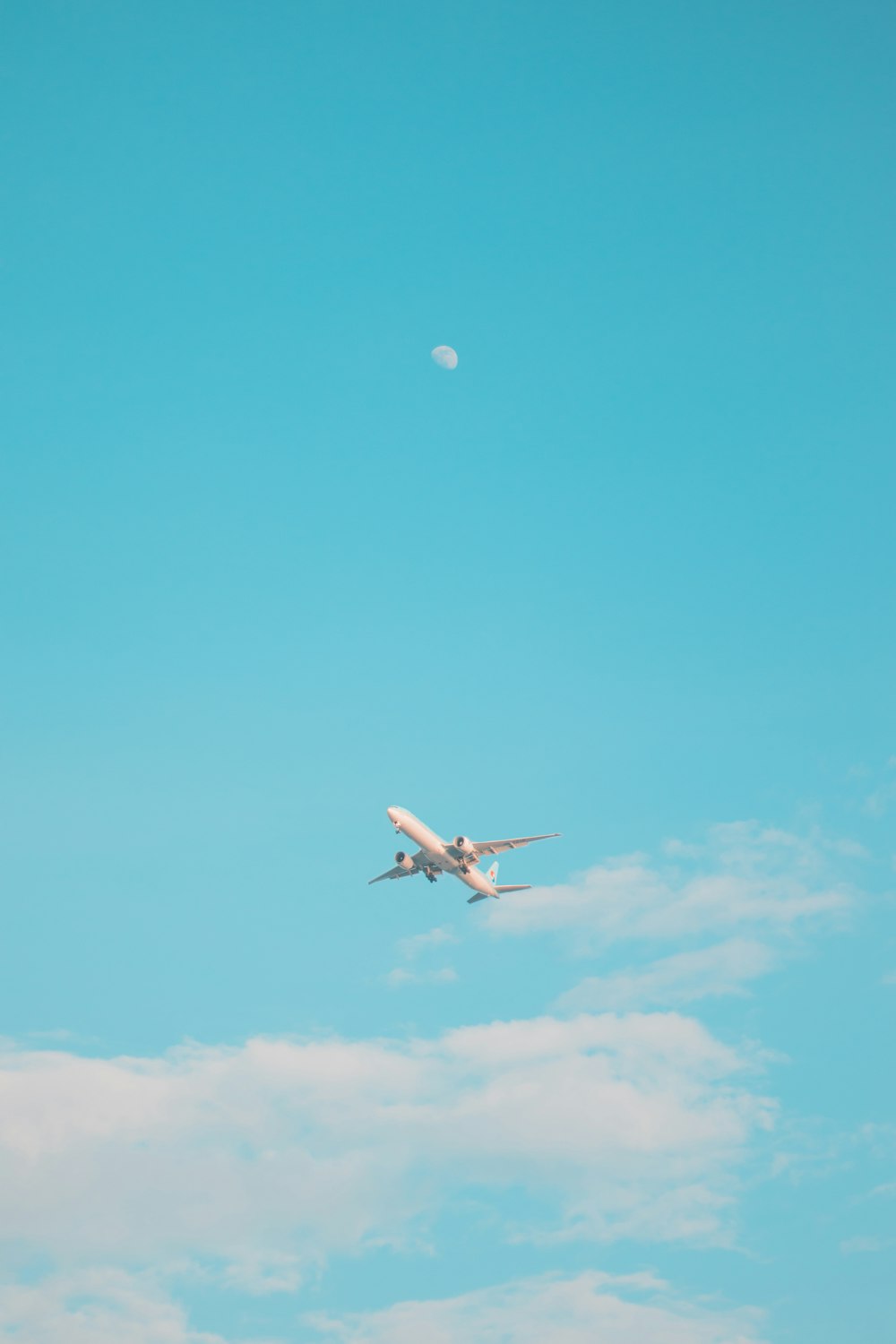an airplane flying in the sky with a moon in the background
