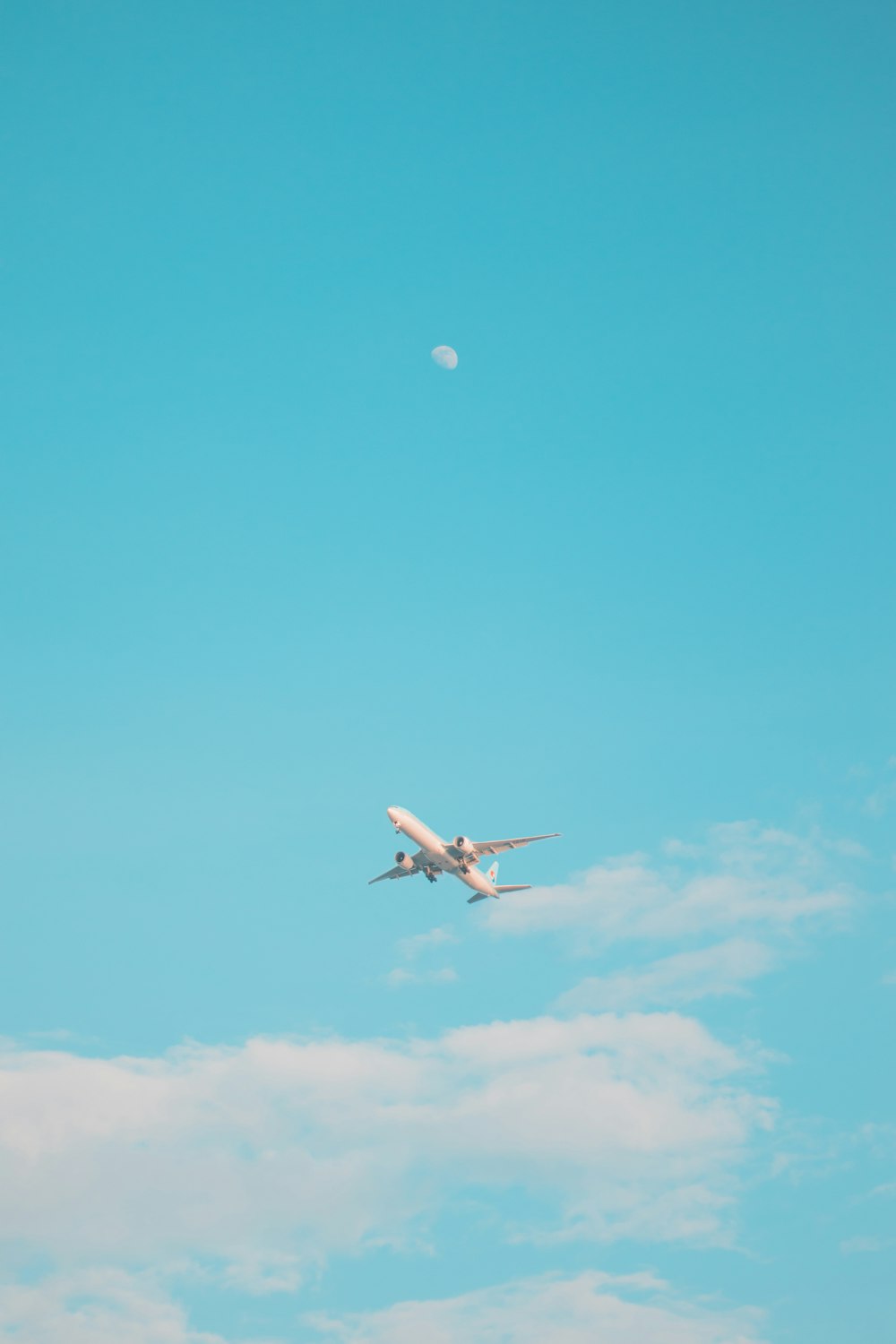 Un avión volando en el cielo con una luna en el fondo