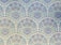 An intricate floral pattern featuring a symmetrical arrangement of various stylized flowers and leaves. The design predominantly uses soft pastel colors, creating a harmonious and decorative effect.