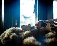 A client and reader sharing a quiet moment of reflection during a tarot session surrounded by soft fabrics.