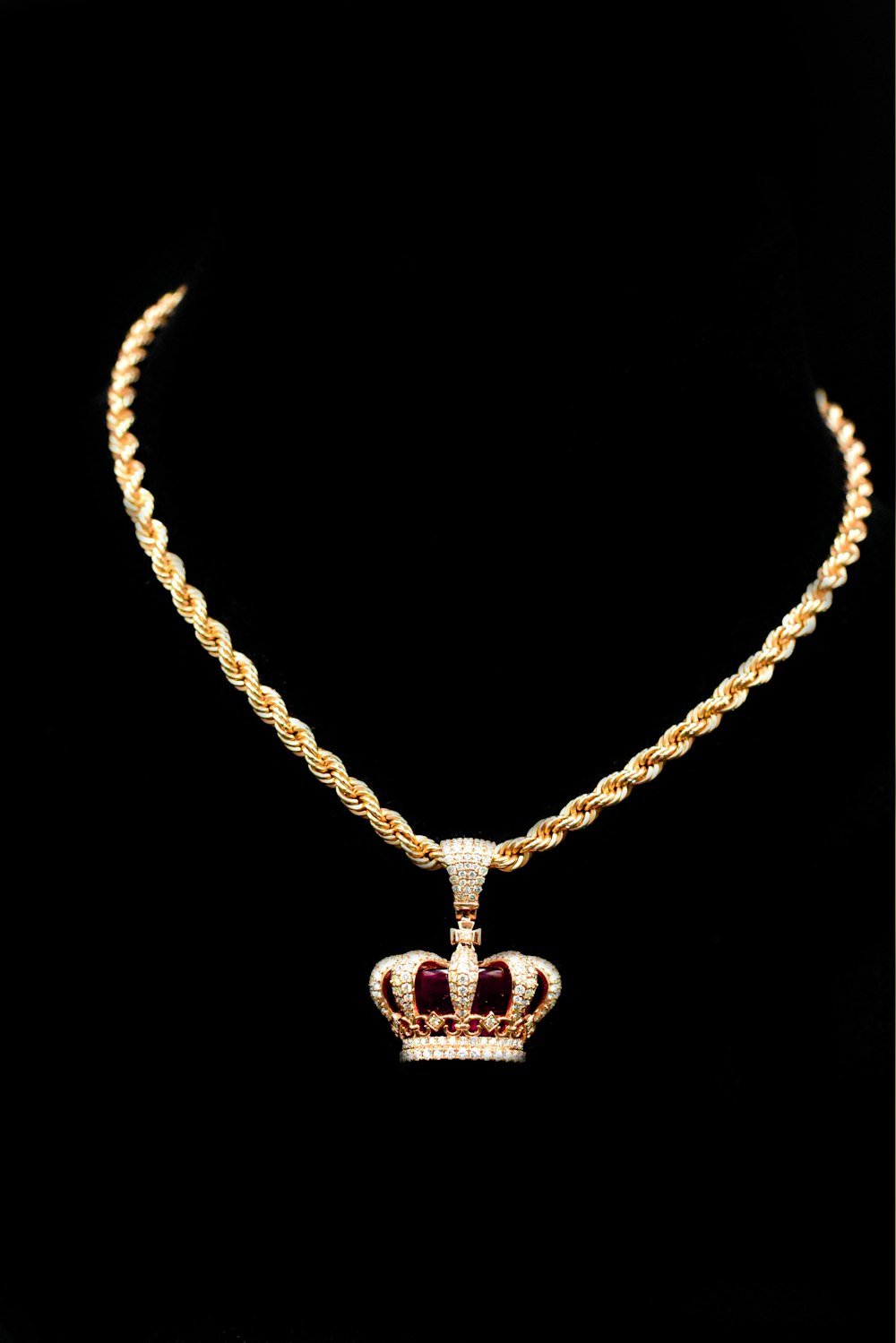 a gold necklace with a crown on it