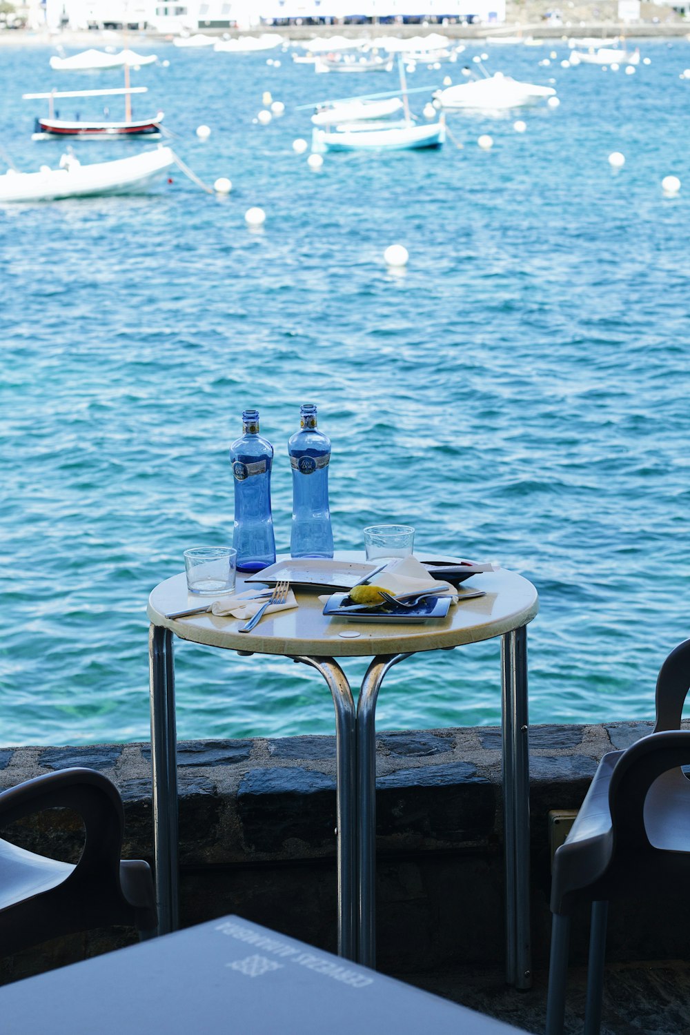 a table with two water bottles and a plate of food on it