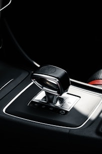 A close-up view of an automatic car gear shift surrounded by a sleek modern console.