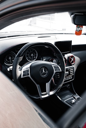 Premium car essentials including a leather steering wheel cover and elegant air freshener in black and gold