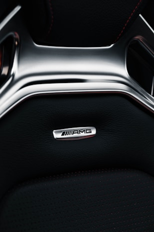 Mercedes-Benz interior with black leather seats and golden stitching illuminated by ambient light.