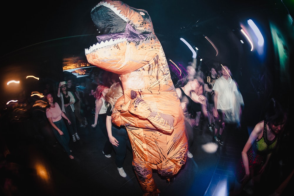 a man in a dinosaur costume dancing at a party