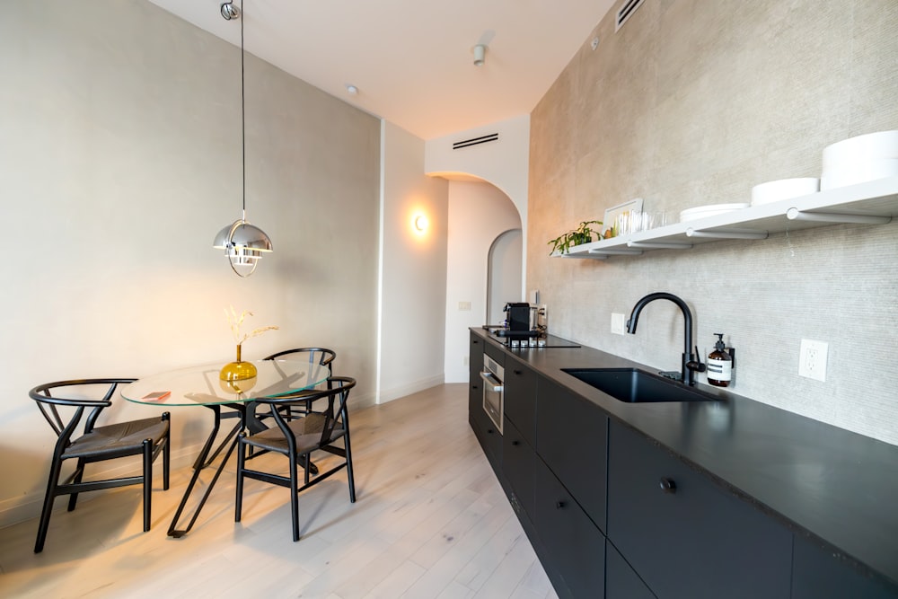 a kitchen with a table, chairs and a sink