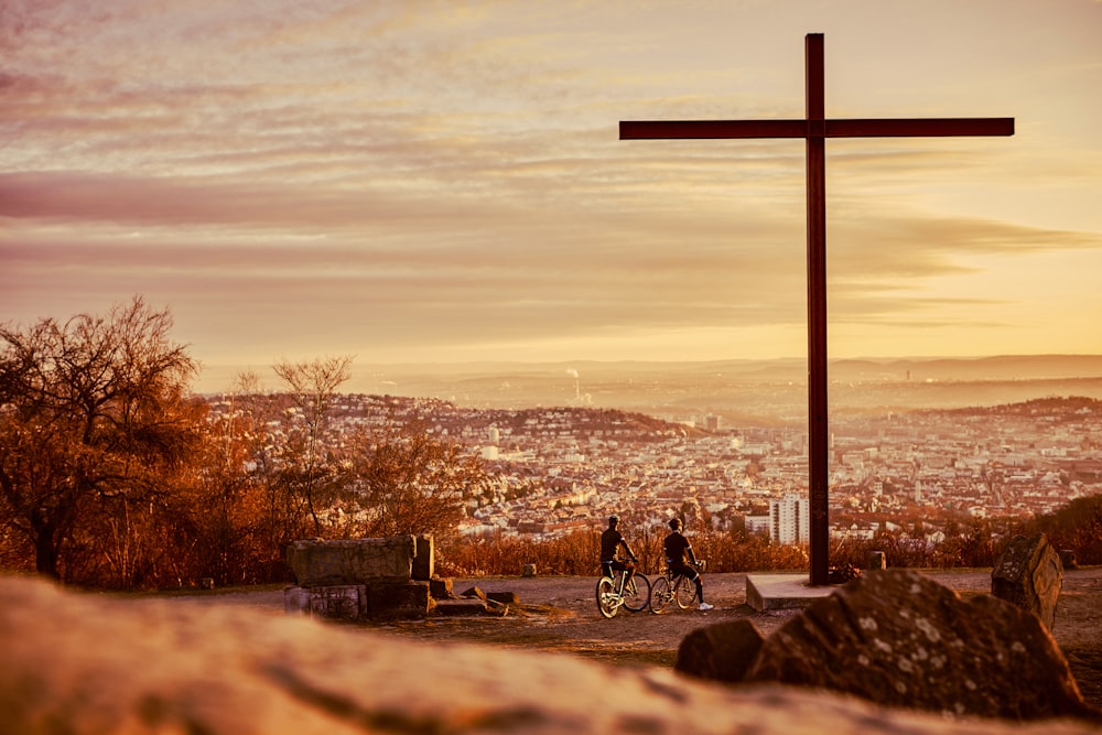 a cross on top of a hill overlooking a city