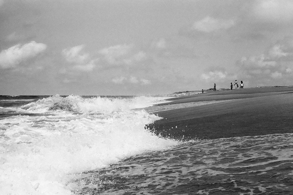 a black and white photo of waves crashing on a beach
