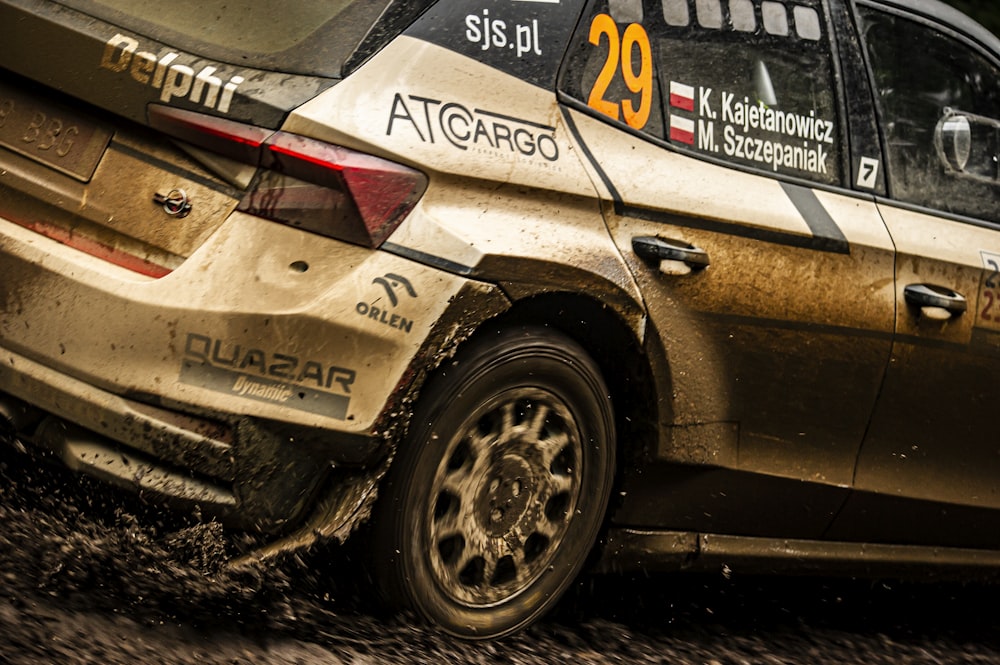 a rally car driving through a muddy road