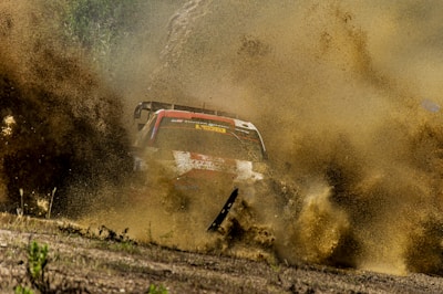 A dramatic mid-air jump over a dirt track, dust trailing behind the speeding vehicle.