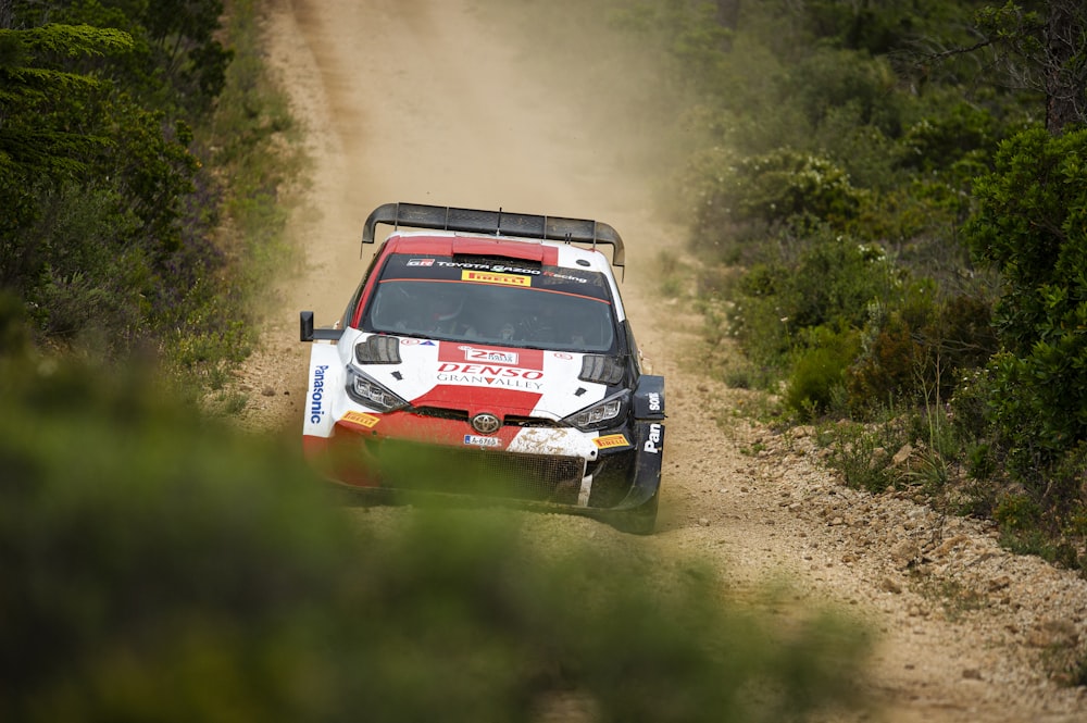 a rally car driving down a dirt road