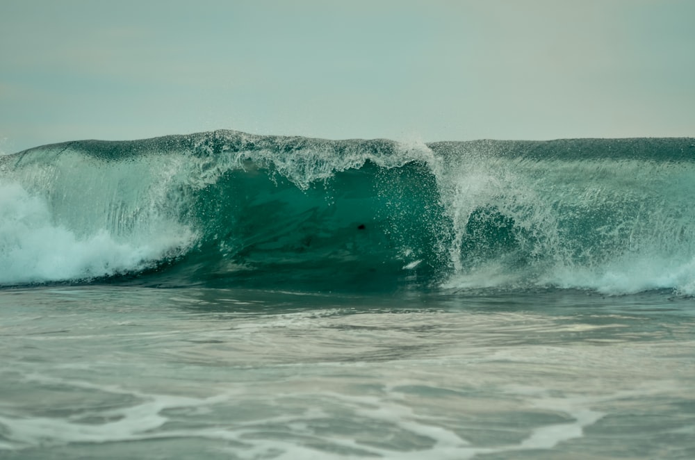 a man riding a wave on top of a surfboard