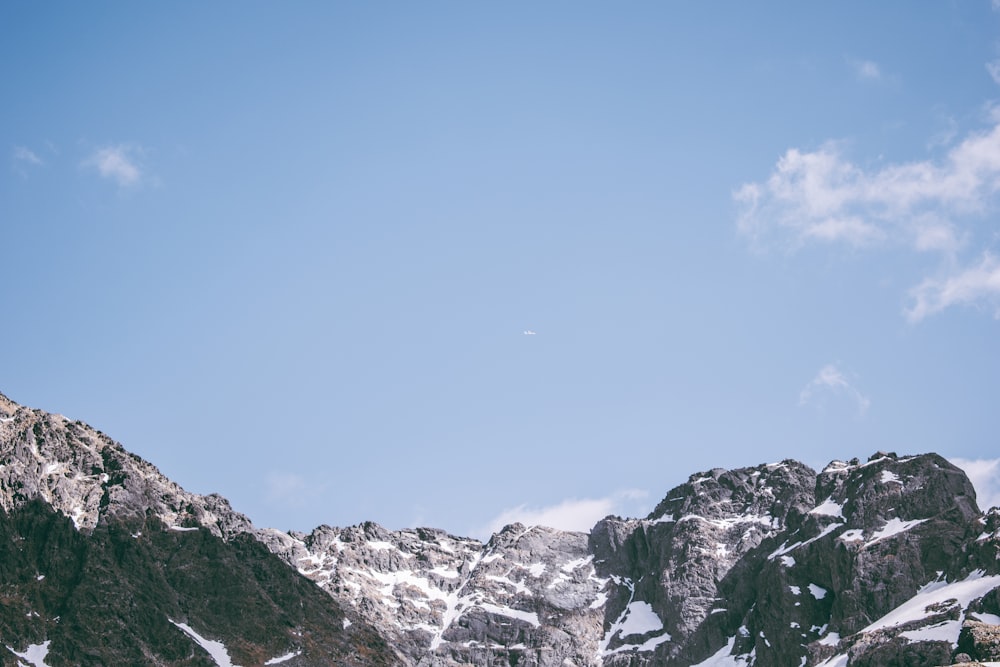 a group of mountains covered in snow under a blue sky