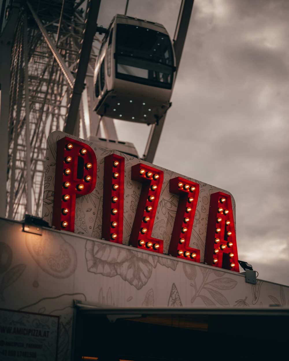 a sign that says pizza on top of a building