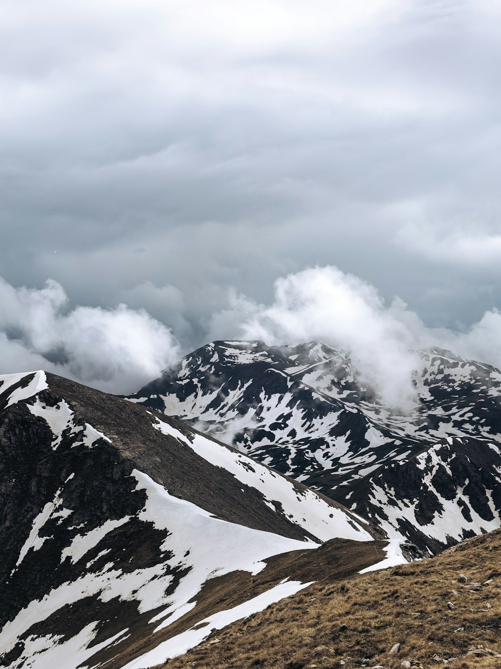 a mountain range covered in snow and clouds