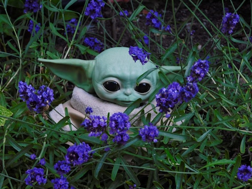 A friendly alien holding a cannabis leaf, surrounded by colorful exotic plants under a starry sky.