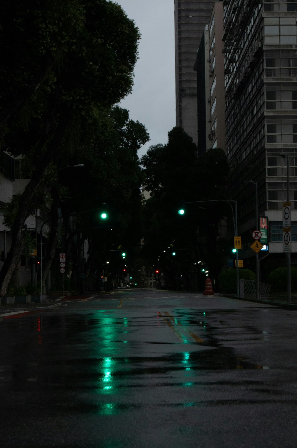a city street at night with green street lights
