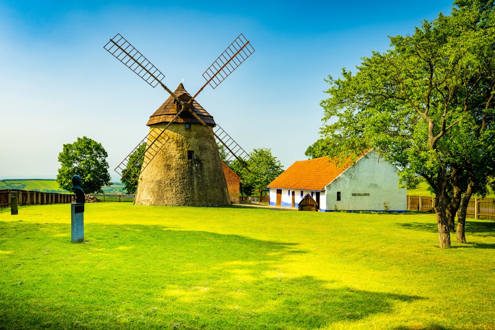 a couple of windmills sitting on top of a lush green field