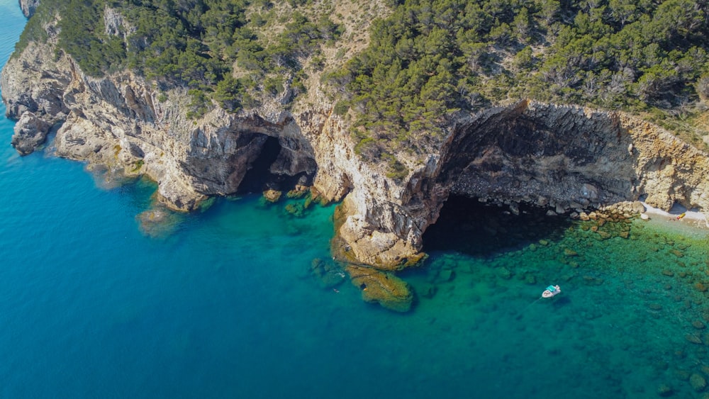 an aerial view of a beach with a boat in the water