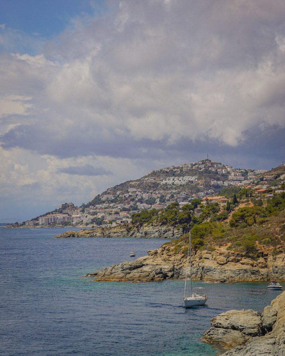 a sailboat on a body of water with a city in the background