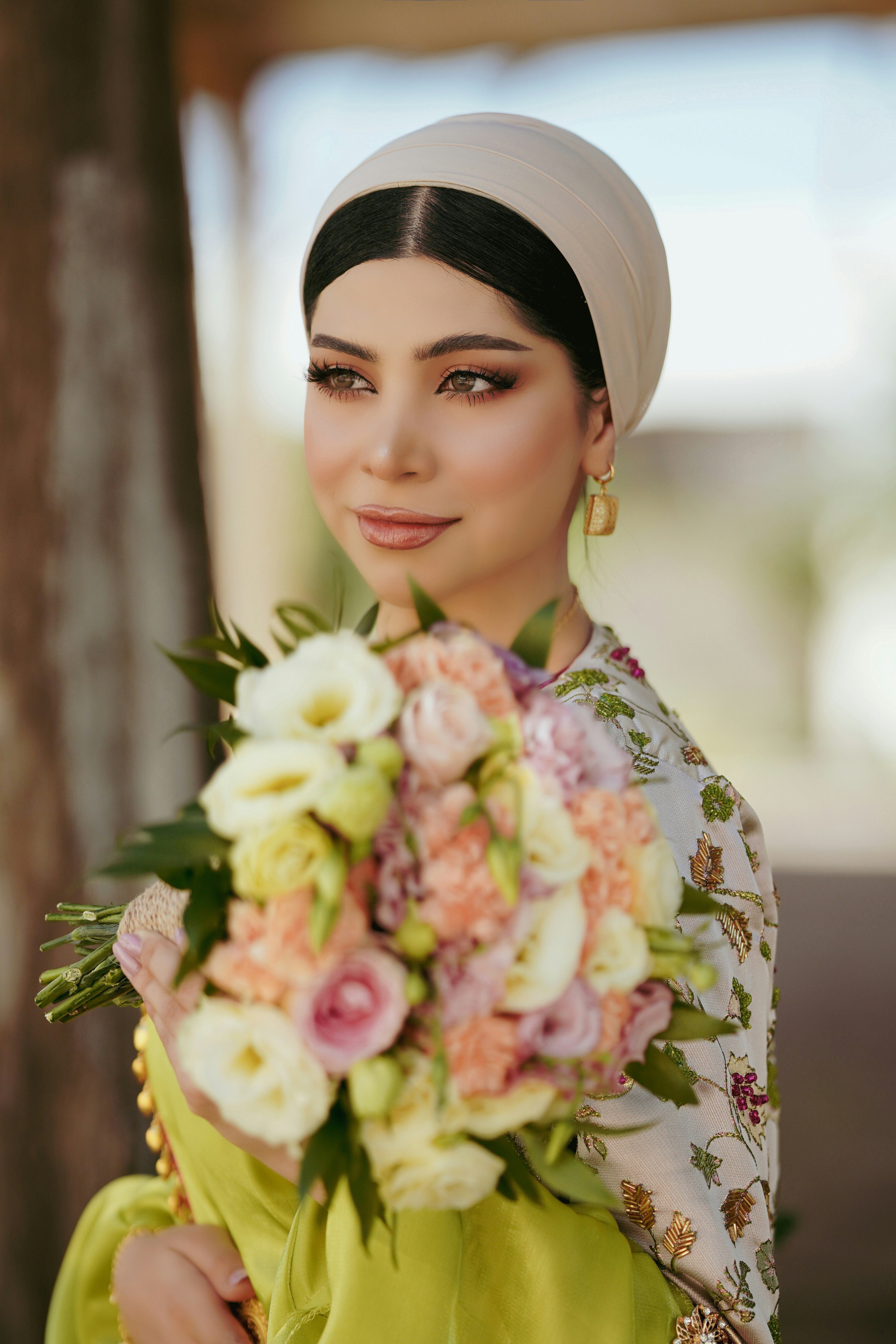 Seorang wanita berjilbab memegang buket bunga