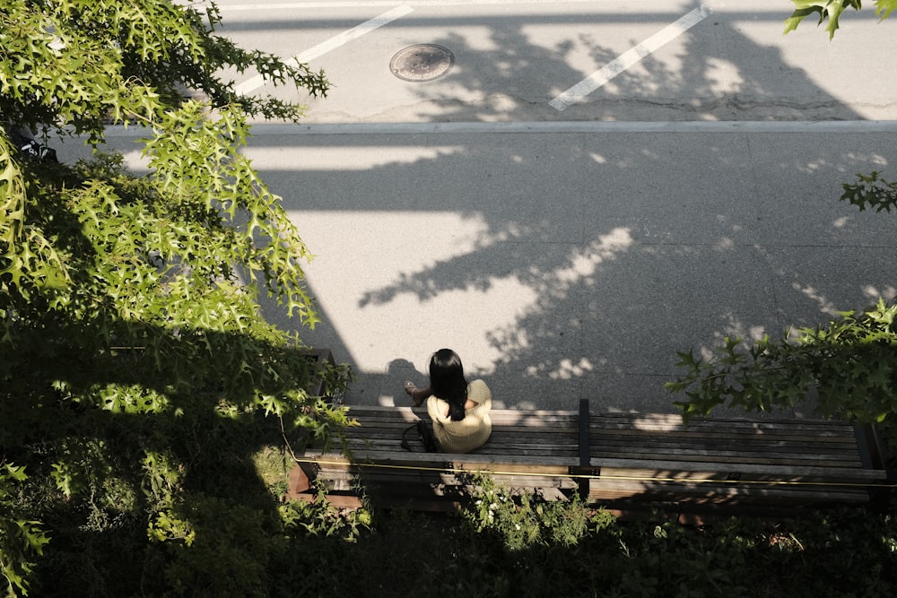 a person sitting on a bench in a park