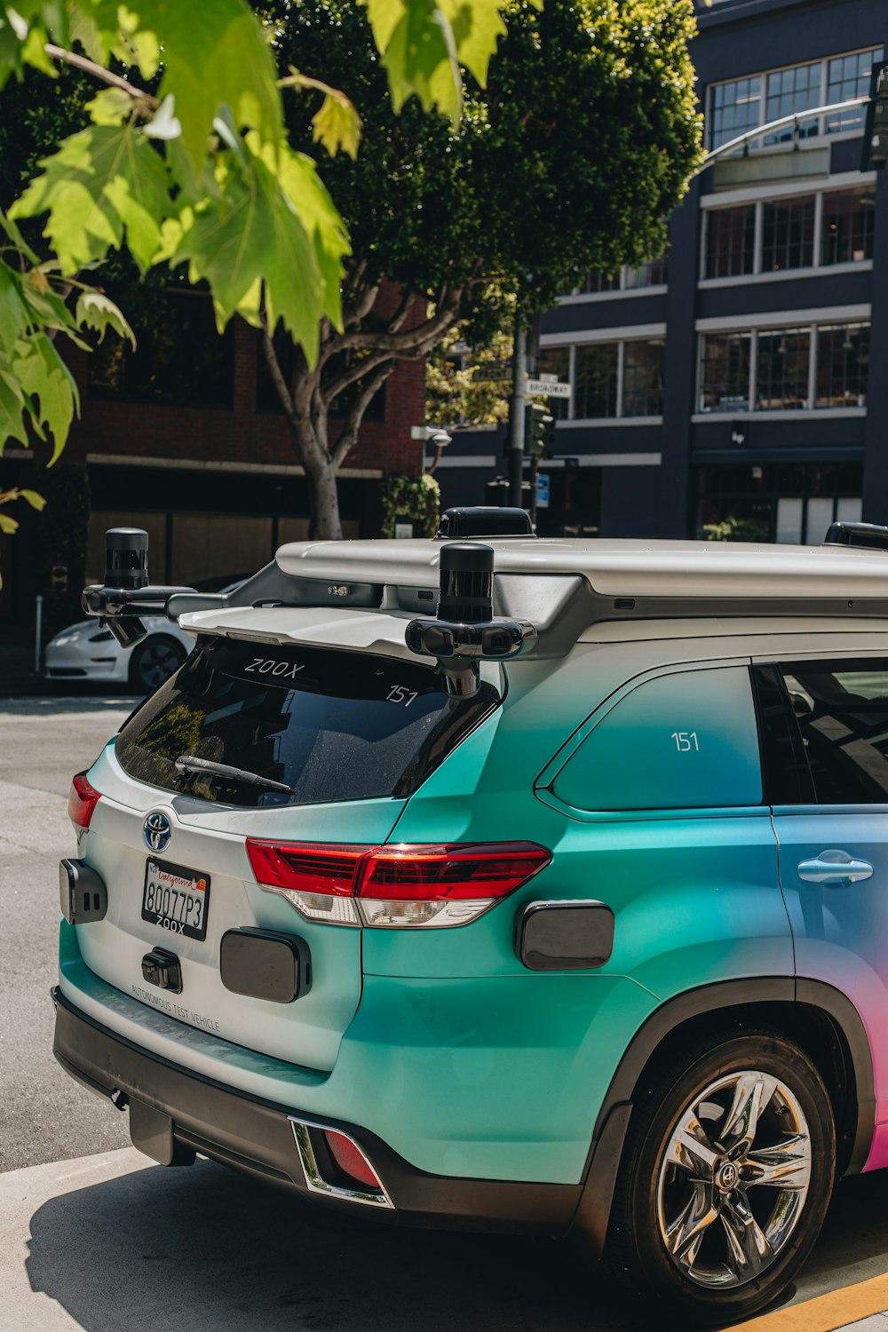 a car parked on the side of the road with a surfboard on top of