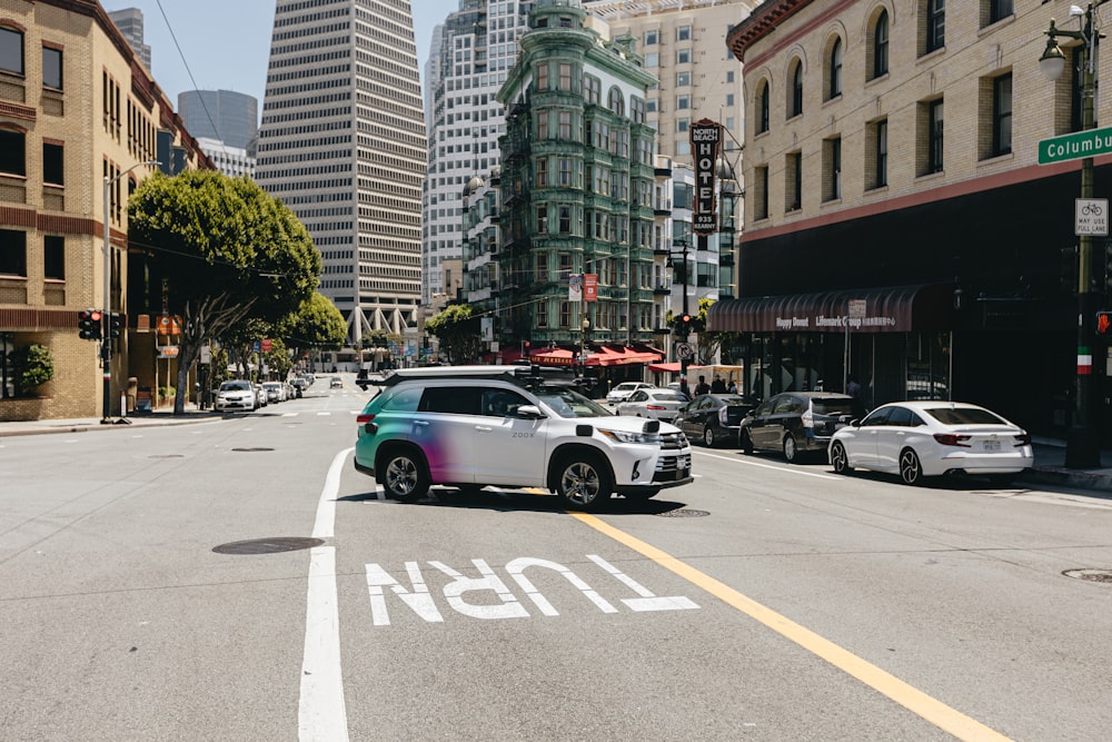 a car driving down a street next to tall buildings