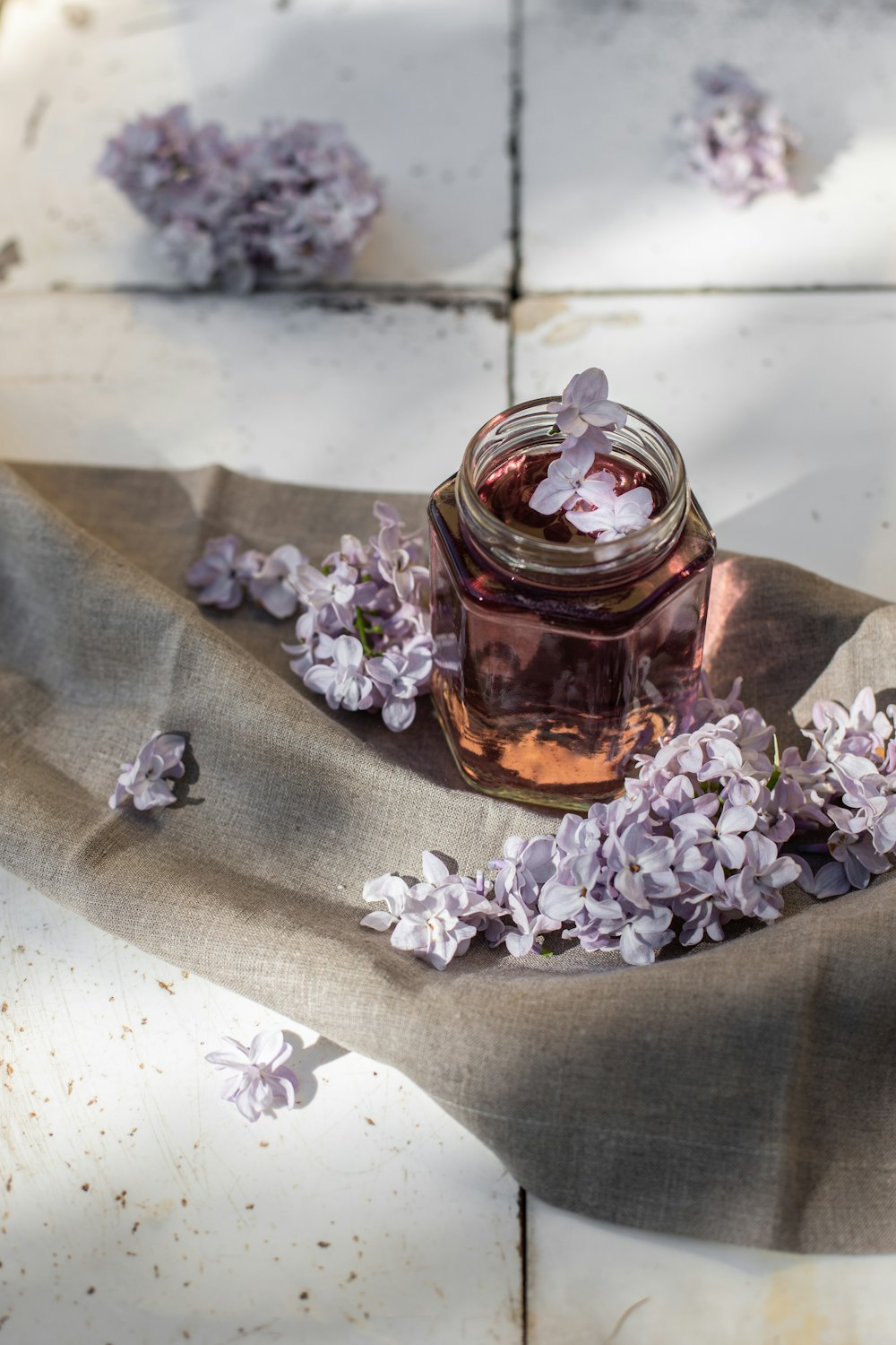 a jar filled with purple flowers sitting on top of a table