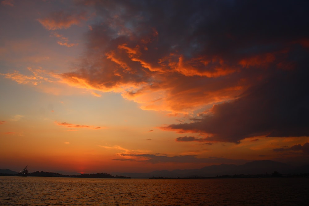 Ein Sonnenuntergang über einem Gewässer mit Wolken am Himmel