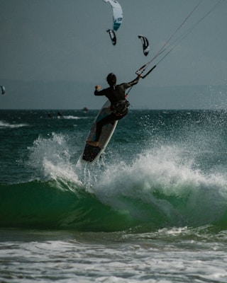 a man riding a surfboard on top of a wave