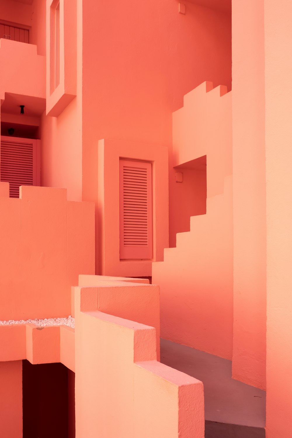 a pink building with stairs and a door