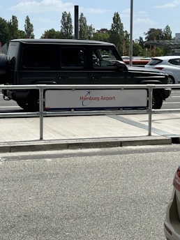 A sleek taxi waiting outside Hamburg Airport terminal at dusk