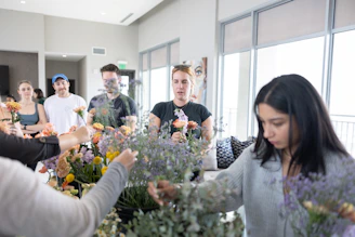 A group of people standing around a table with flowers