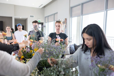 A group of people standing around a table with flowers