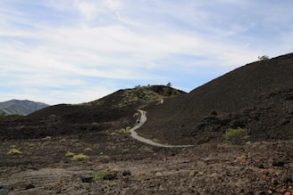 A vibrant trail winding through tropical forest near a volcano.