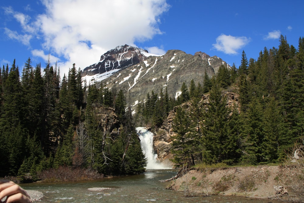 a person taking a picture of a waterfall