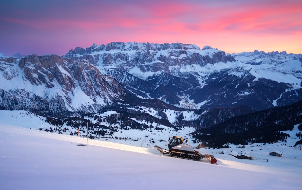 a snowboarder is sitting in the snow at the top of a mountain