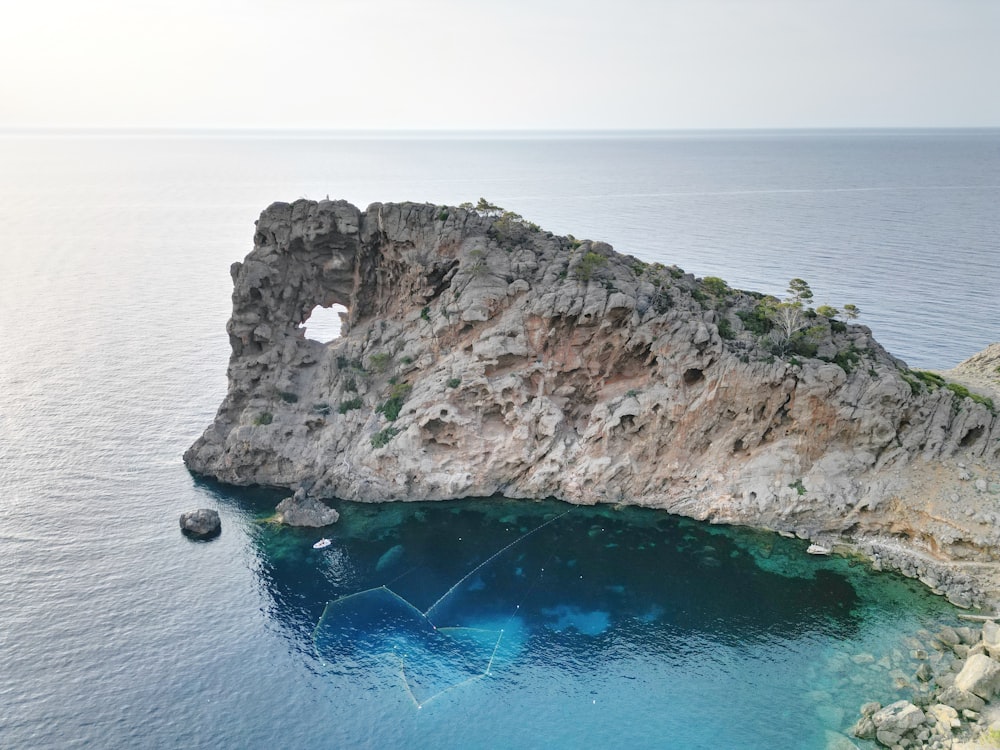 an aerial view of a rock outcropping in the ocean