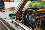 Interior shot showing the restored leather seats and wooden dashboard of a classic Mercedes