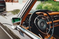 A classic Mercedes-Benz steering wheel with original leather grip, softly lit.