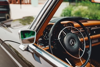 A classic Mercedes-Benz steering wheel with original leather grip, softly lit.