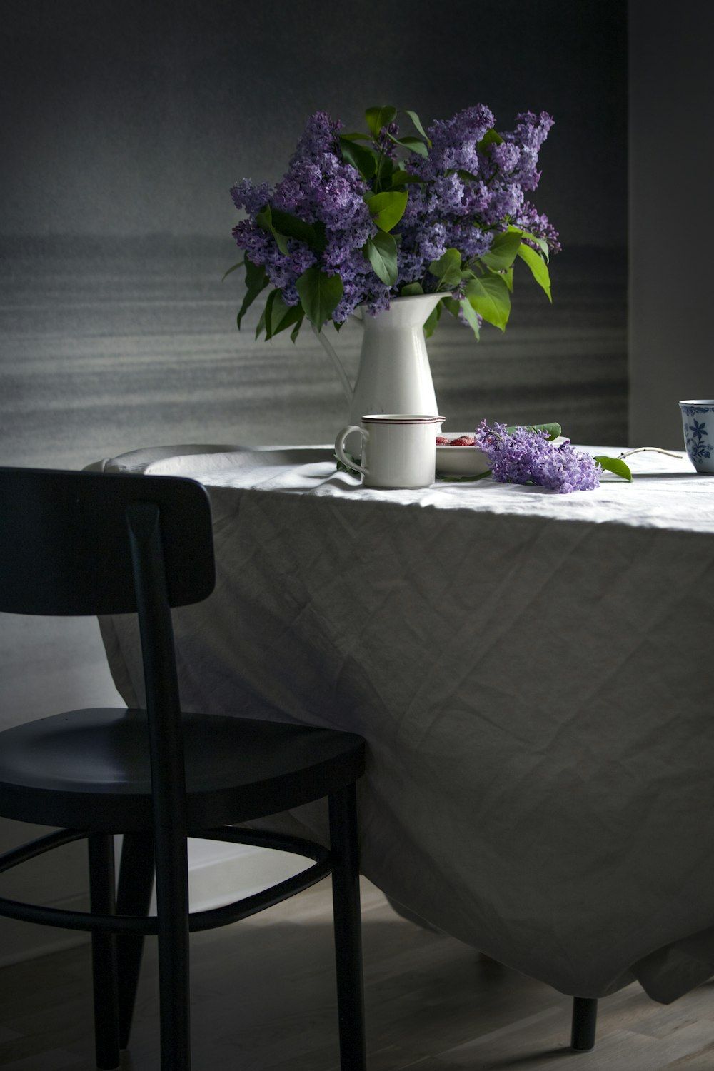 a table with a vase of purple flowers on it