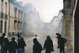 Volunteers in black hoodies handing out meals under streetlights at night with subtle smoke around.