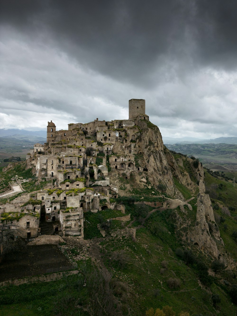 Un castillo encaramado en la cima de una montaña bajo un cielo nublado