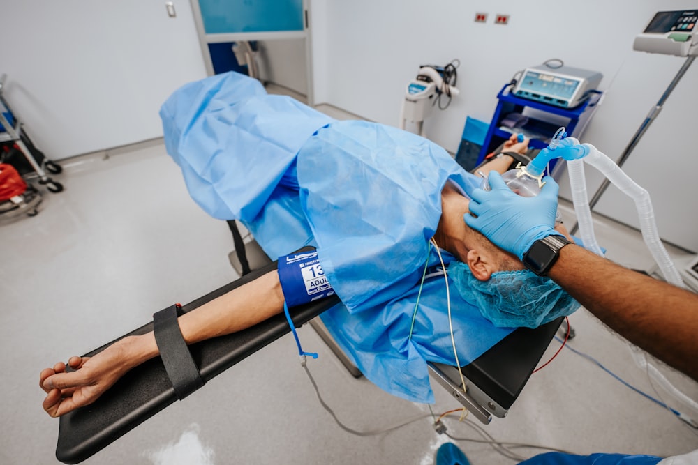 a person laying on a hospital bed in a room